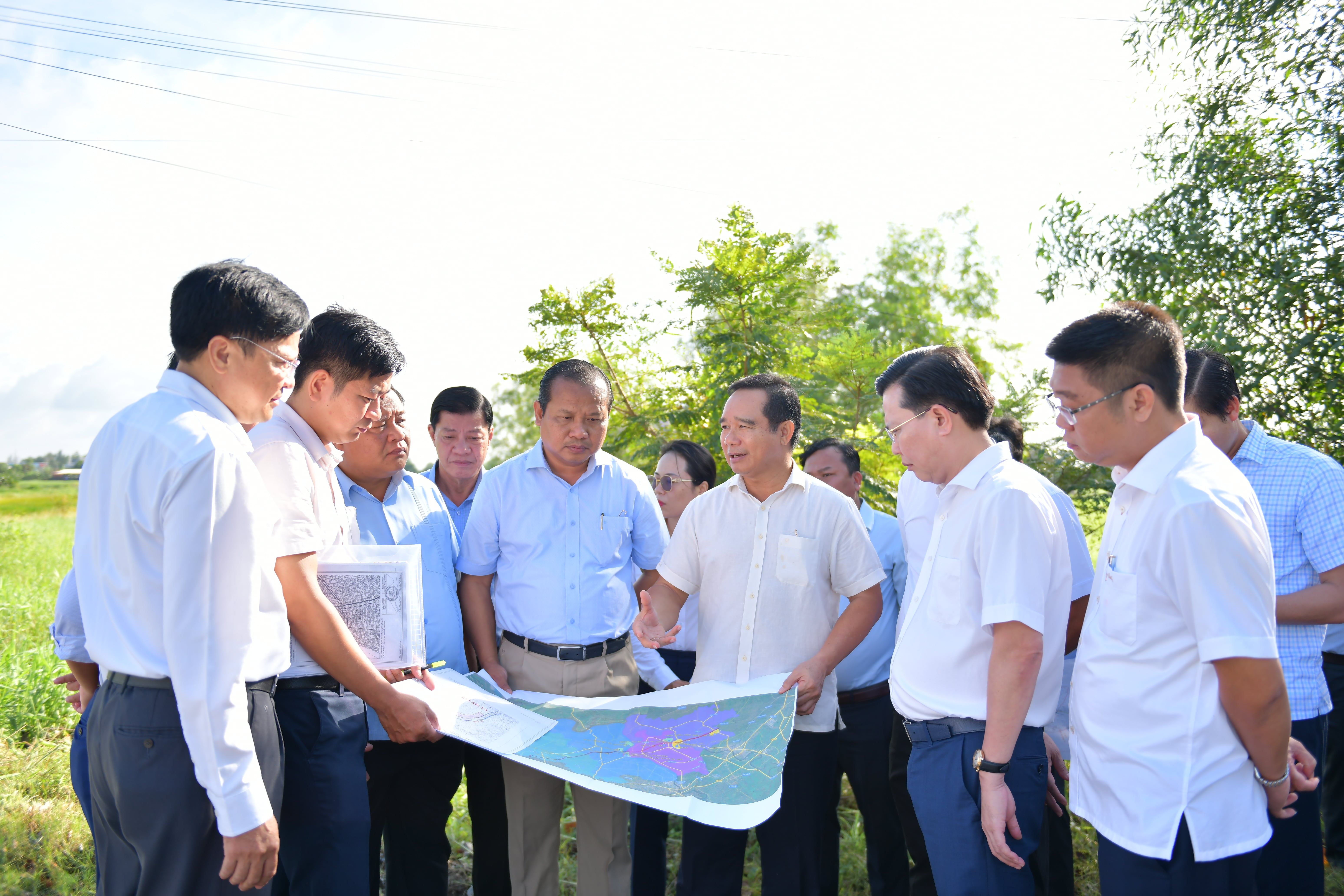 Leaders of the Long An authorities survey the construction site of a road leading to a bridge on Provincial Road 827E.