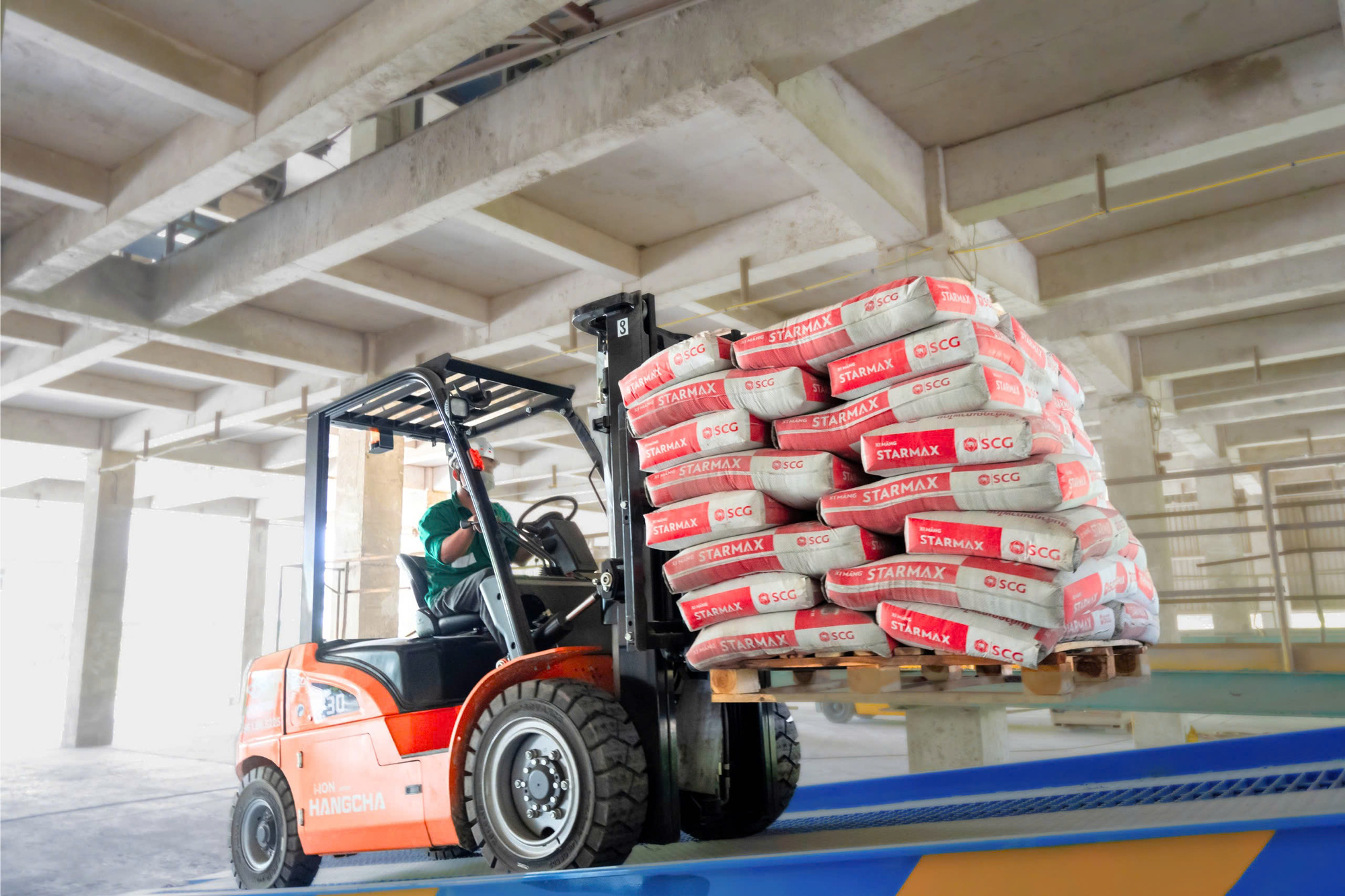 A worker operates a forklift carrying bags of STARMAX cement at an SCG facility. Photo: SCG