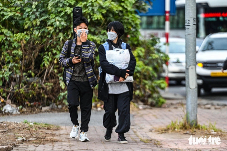 Two young people walk through the Phap Van intersection in Hanoi, Vietnam after getting off a long-haul bus stuck in a prolonged traffic jam. Photo: Hong Quang / Tuoi Tre