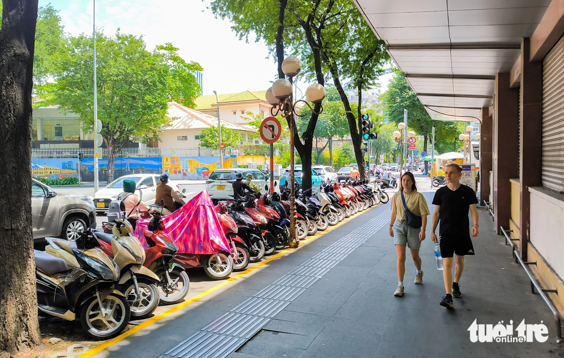 People walk on the sidewalk on Hai Ba Trung Street in District 1, Ho Chi Minh City. Photo: Le Phan / Tuoi Tre