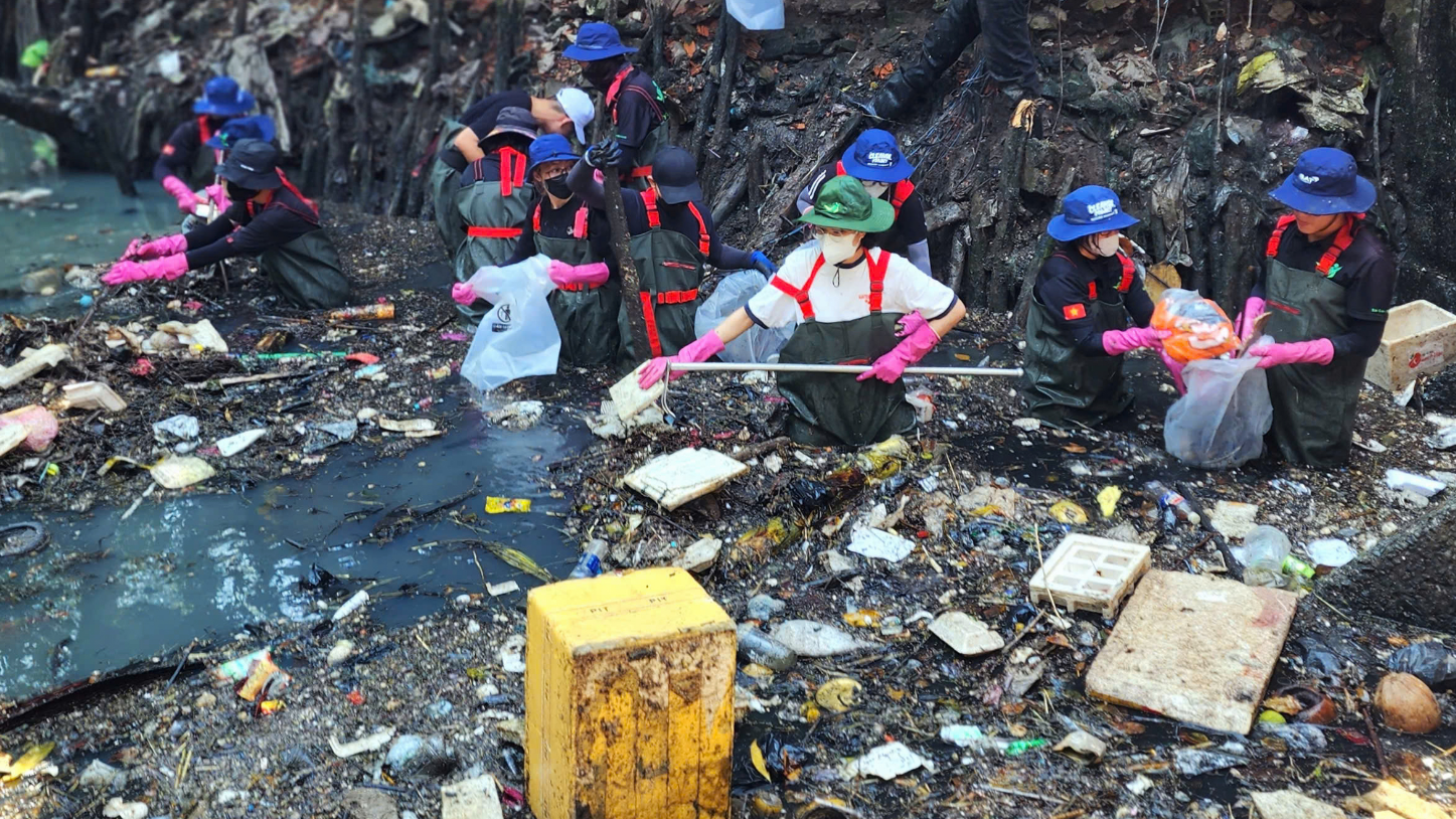 Volunteers, equipped with protective gear, remove trash from Hy Vong Canal in Tan Binh District, Ho Chi Minh City on March 1, 2025. Photo: Ngoc Khai / Tuoi Tre
