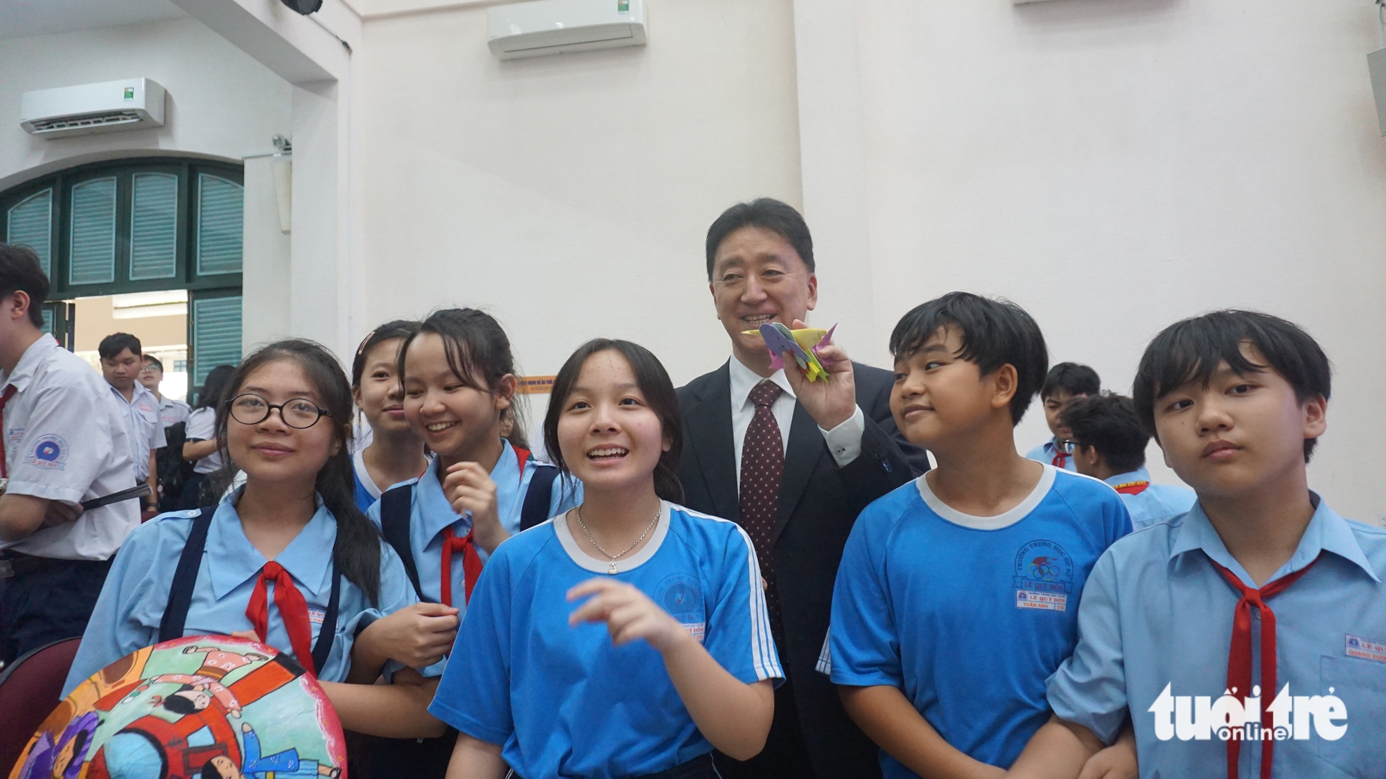 Students from Le Quy Don Middle School pose for a photo with Deputy Consul General of Japan in Ho Chi Minh City, Seiki Furudate, at Le Quy Don High School in District 3, Ho Chi Minh City, March 7, 2025. Photo: My Dung / Tuoi Tre