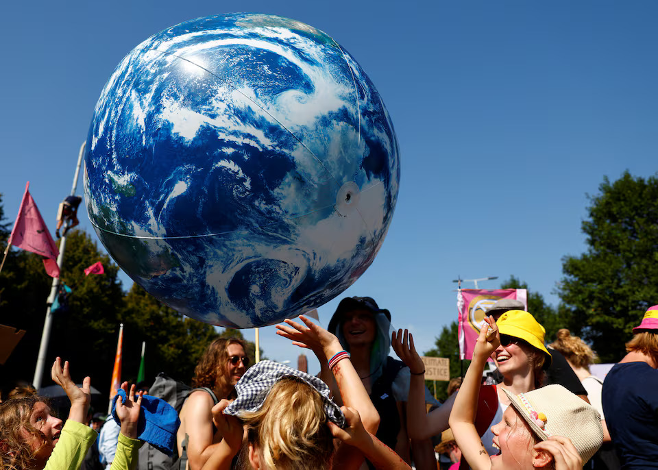 Climate activits play with an inflatable representation of the planet Earth. Photo: Reuters