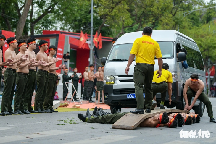Public security officers exhibit qigong skills by enduring a car driving over them at a rehearsal in Hanoi, Vietnam, March 7, 2025. Photo: Nam Tran / Tuoi Tre