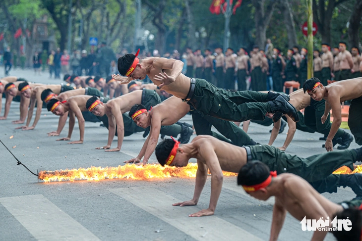 Public security officers perform push-up jumps over a flaming rope during a rehearsal in Hanoi, Vietnam, March 7, 2025. Photo: Nam Tran / Tuoi Tre