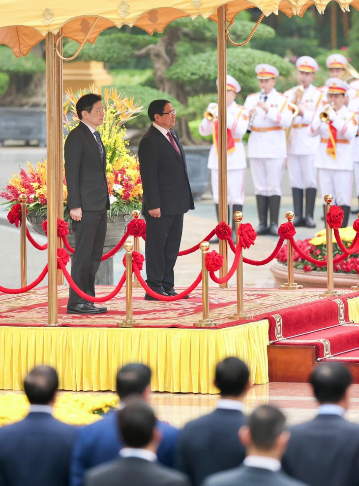 Vietnamese Prime Minister Pham Minh Chinh and his Singaporean counterpart Lawrence Wong attend the welcome ceremony for the latter in Hanoi, March 26, 2025. Photo: Nguyen Khanh / Tuoi Tre