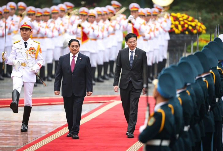 Vietnamese Prime Minister Pham Minh Chinh and his Singaporean counterpart, Lawrence Wong, review the guard of honor in Hanoi, March 26, 2025. Photo: Nguyen Khanh / Tuoi Tre