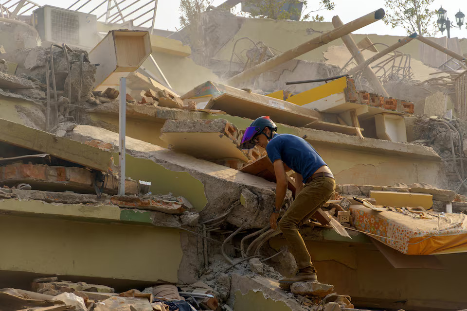 [9/11]A man walks the rubble of the building that collapsed following a strong earthquake, in Mandalay, Myanmar, March 29.  Photo: Reuters