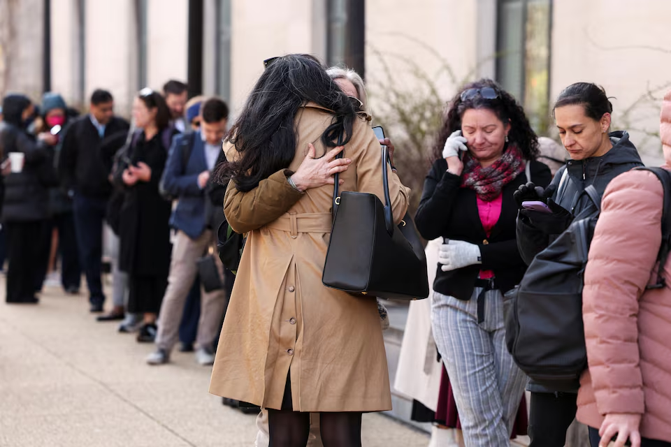 Employees of the Department of Health and Human Services (HHS) hug each other as they queue outside the Mary E. Switzer Memorial Building, after it was reported that the Trump administration fired staff at the Centers for Disease Control and Prevention and at the Food and Drug Administration, as it embarked on its plan to cut 10,000 jobs at HHS, in Washington, D.C., U.S., April 1, 2025. Photo: Reuters