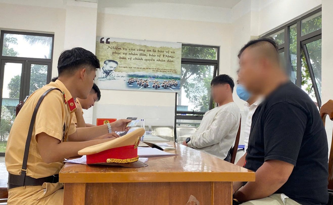 Traffic police in Quang Nam Province, central Vietnam question the owners of two high-capacity motorcycles and two South Koreans who were found riding the motorcycles with both hands off the handlebars. Photo: Trang Phuong