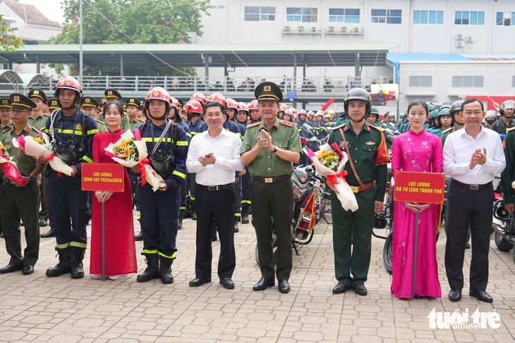 Leaders of the Ho Chi Minh City People’s Committee and the Ho Chi Minh City Police give flowers to police officers. Photo: Huu Hanh / Tuoi Tre