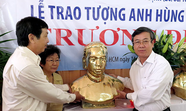 Ông Nguyễn Tấn Phong, phó giám đốc Sở VH-TT&DL Tiền Giang (phải), nhận tượng Trương Định từ đại diện Xưa & Nay và họ Trương VN - Ảnh: L.Điền