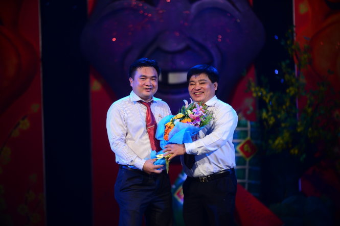 Ông Lê Thế Chữ (phải) - phó tổng biên tập báo Tuổi Trẻ tặng hoa cám ơn ông Đinh Viết Thuận giám đốc chi nhánh công ty TNHH Nhà nước Một thành viên Yến sào Khánh hòa tại TP.HCM, đơn vị tài trợ cho lễ trao giải Cù nèo vàng 2014 - Ảnh: Quang Định