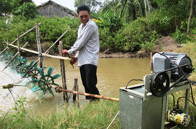 Ông Nam sử dụng thiết bị tiết kiệm điện trong nuôi tôm - Ảnh: Sơn Bình