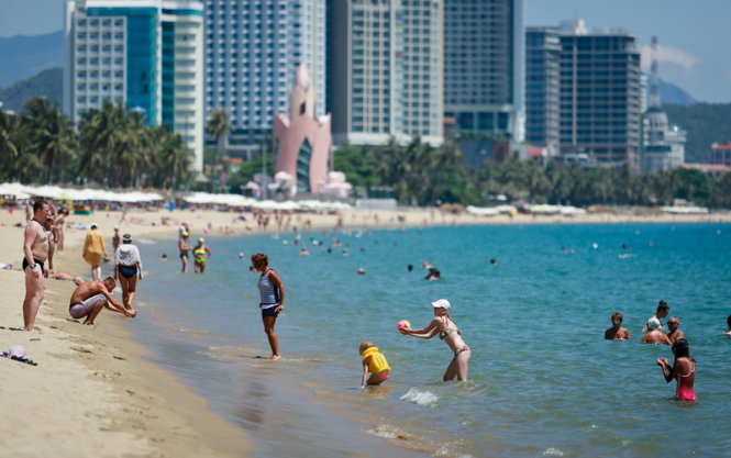Du khách dạo chơi trên bờ biển Nha Trang. Ảnh: TIẾN THÀNH