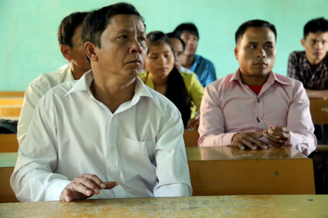 Thí sinh 55 tuổi Hồ Văn Hinh chăm chú nghe giám thị phổ biến quy chế thi vào sáng 30-6 - Ảnh: Ngọc Hiển
