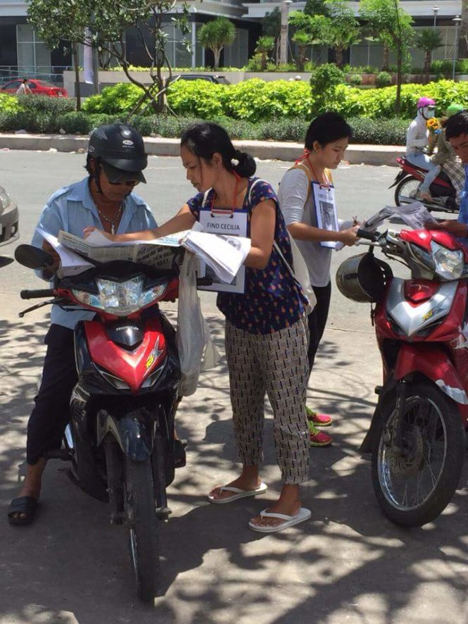 Chị Ela phát tờ rơi tìm con. (Ảnh facebook