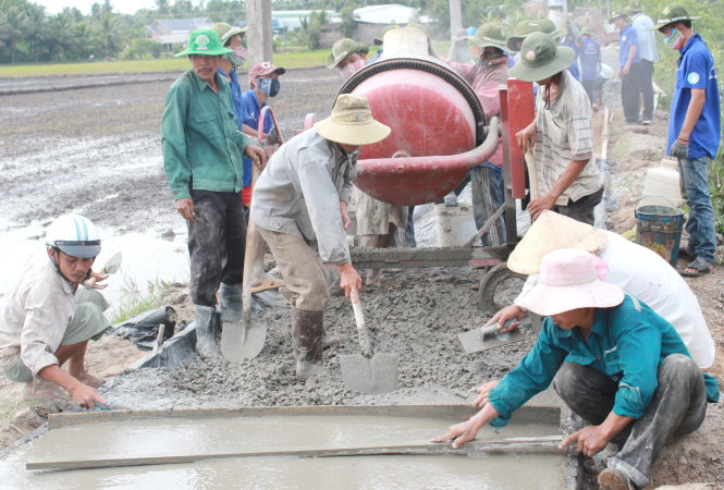 Nhiều người dân cùng ra làm với chiến sĩ, hình ảnh quen thuộc trên công trình Mùa hè xanh 2015 tại Trà Vinh Ảnh: Q.L.