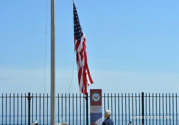 Ngoại trưởng John Kerry nhìn lá cờ được kéo lên tại đại sứ quán Mỹ ở Havana, Cuba - Ảnh: AFP