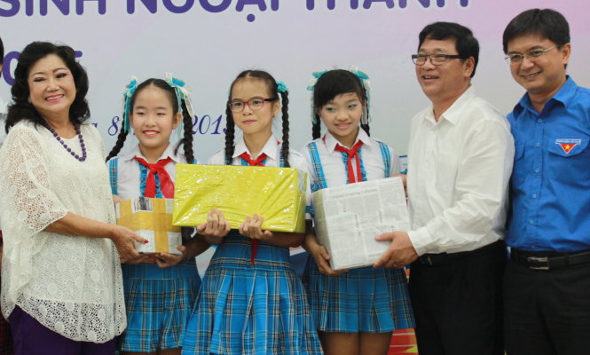 NSND Kim Cương (bìa trái) cùng Bí thư Thành đoàn TP.HCM Nguyễn Mạnh Cường (bìa phải) và phó chủ tịch Hội Xuất bản VN Lê Hoàng tặng sách cho đại diện các học sinh ngoại thành TP.HCM - Ảnh: Q.L.