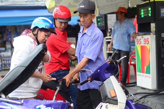 Người dân đổ xăng trên đường Nơ Trang Long, Q.Bình Thạnh lúc 3g chiều 19-8. Xăng Ron 92 giảm giá xuống còn 18.530 đồng/lít  - Ảnh: Thanh Tùng