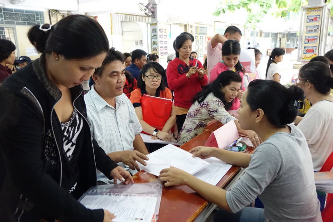 Phụ huynh đến nộp hồ sơ nhập học cho học sinh lớp 6 tại Trường THCS Kim Đồng, Q.5, TP.HCM. Đây là quận không đòi hỏi phải có hộ khẩu khi tiếp nhận học sinh - Ảnh: Như Hùng
