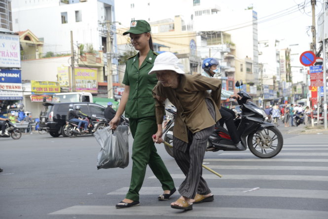 Những hành động đẹp này cần được nhân lên trong cộng đồng. Trong ảnh: Chị Nguyễn Thị Bích Vân, thanh niên xung phong,  trực tại trạm giao thông trọng điểm đoạn Xô Viết Nghệ Tĩnh - Bạch Đằng  (TP.HCM),  giúp đỡ dẫn cụ già qua đường, sáng 31-8 - Ảnh: DUYÊN PHAN