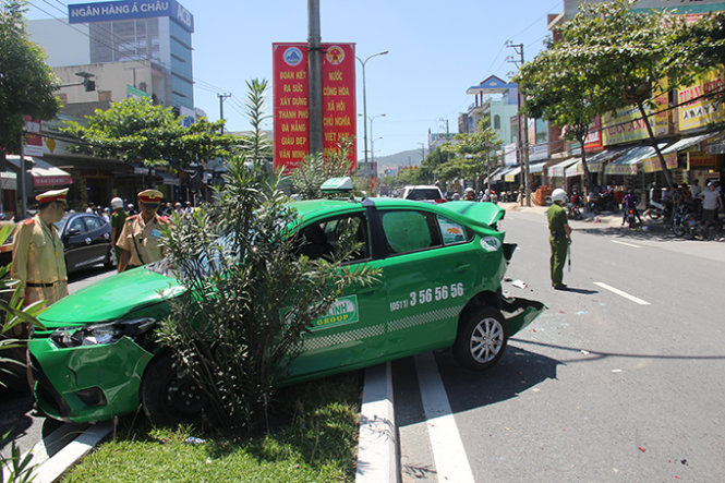 Xe taxi bay lên dải phân cách bị bẹp dúm phần đuôi - Ảnh: Trường Trung