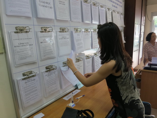 Người dân xem quy trình thủ tục hành chính tại UBND quận 4, TP.HCM - Ảnh: T.T.D.