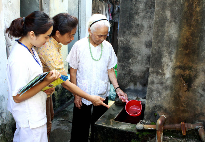 Nhân viên y tế phường Hoàng Văn Thụ, quận Hoàng Mai (Hà Nội) đi kiểm tra lăng quăng ở các bể nước trong hộ gia đình và tuyên truyền phòng chống dịch bệnh sốt xuất huyết - Ảnh: Dương Ngọc