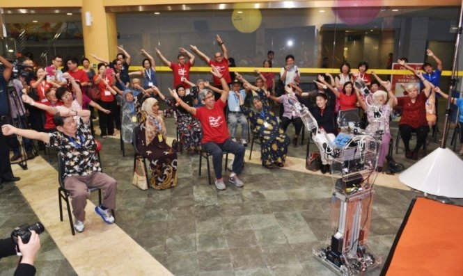 Robot Robocoach đang hướng dẫn người cao tuổi tập thể dục - Ảnh: IDA
