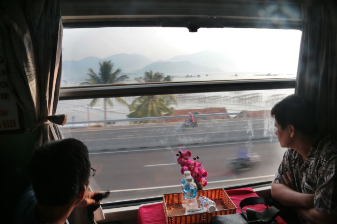 Du khách ngồi trên toa tàu thư thái ngắm cảnh dọc hai bên đường tàu chạy qua - Ảnh: Tiến Long