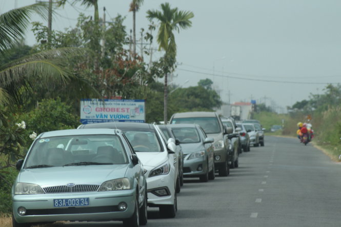 Xe công chở cán bộ dự đám giỗ đậu nối dài một đoạn đường ở Trà Vồn - Ảnh: Tiến Trình