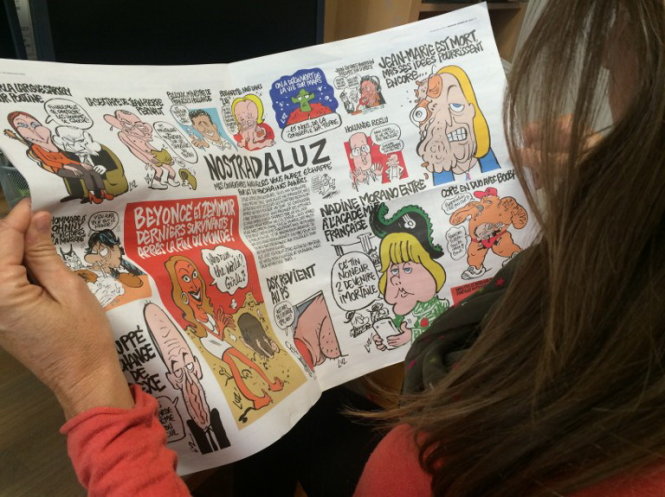 Một nữ độc giả Pháp đọc tạp chí Charlie Hebdo - Ảnh: DPA/AFP