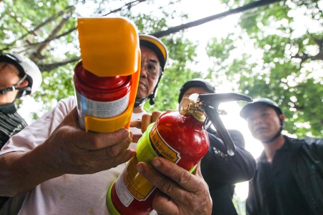 Một người đàn ông tỏ ra băn khoăn không biết mua loại phương tiện chữa cháy nào cho phù hợp (Ảnh Nguyễn Khánh)