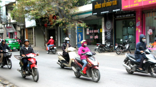 Người Hà Nội trong áo ấm khi ra đường - Ảnh: Tuấn Phùng
