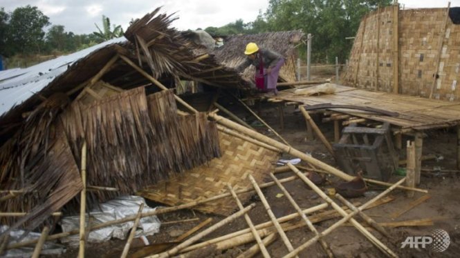 Một người đàn ông đang cố gắng cứu vớt tài sản trong nhà Ảnh: AFP