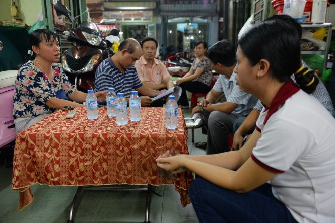 Bà Hà Thị Vân (bìa trái) - chủ tịch UBND P.19, Q.Bình Thạnh, TP.HCM - cùng đại diện Công an P.19, Q.Bình Thạnh nói lời xin lỗi người dân - Ảnh: Hữu Khoa
