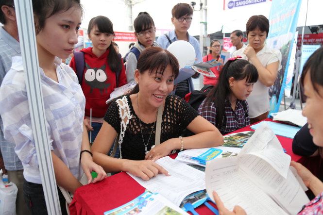 Phụ huynh và thí sinh sau khi nghe tư vấn xét tuyển đã nộp hồ sơ đăng ký xét tuyển trực tiếp tại gian tư vấn ở Ngày hội tư vấn xét tuyển 2015 do báo Tuổi Trẻ và Bộ GD-ĐT phối hợp tổ chức - Ảnh: Như Hùng