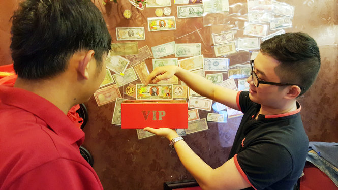 Khách hàng săn lùng tiền lưu niệm hình con khỉ làm quà lưu niệm tại một cửa hàng kinh doanh tiền lưu niệm - Ảnh: Đình Dân