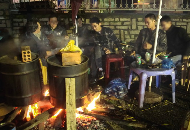 Đến đêm mưa lạnh, họ vẫn cố gắng trông nom nồi bánh - Ảnh: Tuấn Anh