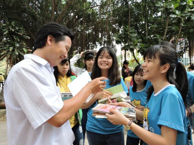 Thầy Huỳnh Văn Thế lì xì sách kèm theo những lời chúc, dặn dò cho học sinh - Ảnh: Thúy Hằng