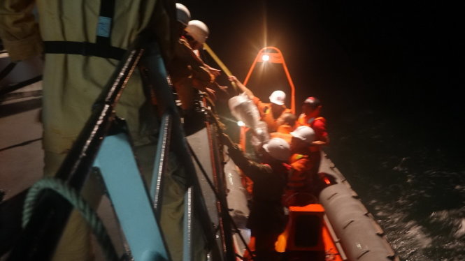 Lực lượng cứu hộ của tàu SAR 412 tiếp cận đưa các thuyền viên tàu Hà Tiên 1 thoát khỏi con tàu bị nước tràn vào - Ảnh: Vietnam MRCC