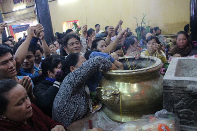 Chen chúc nhau lấy tro trong chùa Bà để cầu may - Ảnh: Đình Trọng