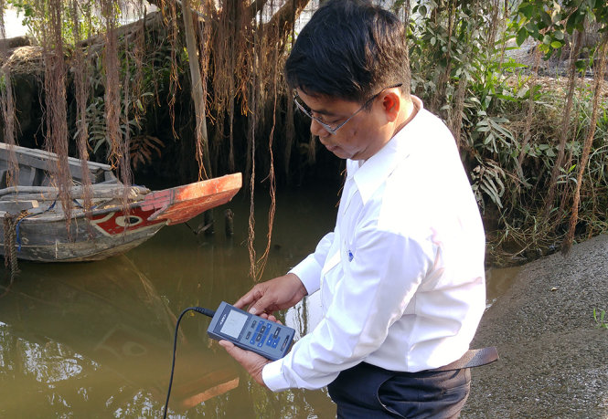 Chuyên viên thủy lợi Long An đo mức độ mặn trê sông Vàm Cỏ Tây vào sáng 23-2 - Ảnh: SƠN LÂM.