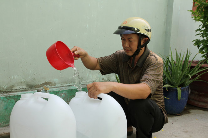 Ông Châu Văn Hiếu ở xã Bình Đông, thị xã Gò Công, tỉnh Tiền Giang phải đi đổi từng can nước ngọt về sử dụng từ trước tết đến nay - Ảnh: V.TR.