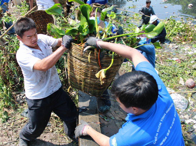Các bạn trẻ địa phương cùng sinh viên TP.HCM tham gia cải tạo, khơi thông dòng chảy rạch Văn Thánh tại P.25, Q.Bình Thạnh (TP.HCM) - Ảnh: Q.L.