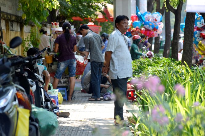 Trước cửa Bệnh viện Giao thông Vận tải (Q.3, Tp.HCM), các gánh hàng rong lấn chiếm hết cả lề đường để buôn bán - Ảnh: Duyên Phan