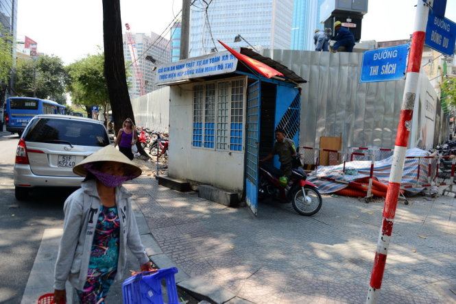 Chốt dân phòng trên đường Đông Du – Thi Sách, Q.1 với khẩu hiệu: “Thực hiện nếp sống văn minh đô thị” nhưng bên cạnh chốt nhem nhuốc hàng rào, bạt che, ống dây cáp. Hai bên lề đường là hai dãi xe máy, trước chốt là những chiếc xe ô tô đậu dưới lòng đường, ảnh chụp sáng 1 -3 - Ảnh: Thanh Tùng