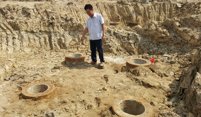 Kỹ sư Mạc Văn Long - đội trưởng đội xây dựng số 5 của công ty Trường Phát - chỉ vào 1 trụ móng bị nghiêng - Ảnh: K.Nam
